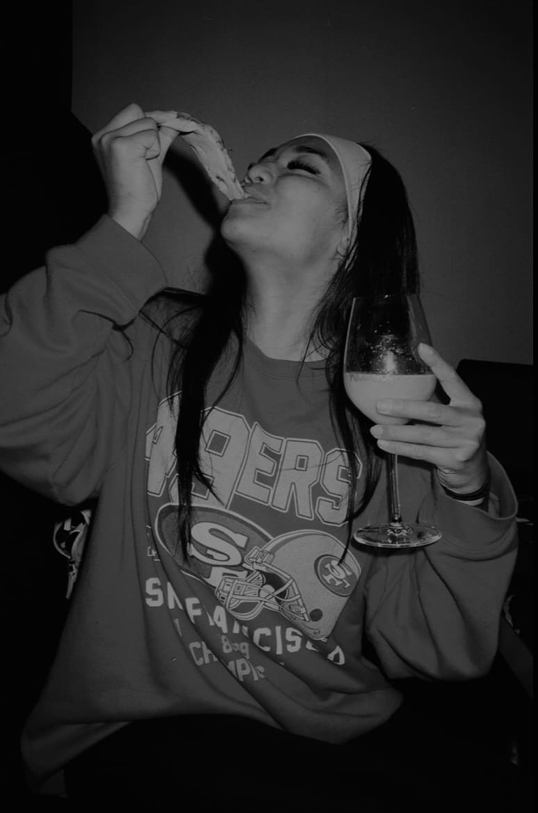 a girl eating pizza black and white photo